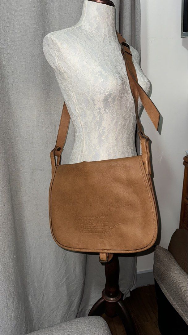 Funky Project Leather Shoulder Bag Tan (Category: Shoulder Bags) located in Mandaluyong City. Submitted by TheWeekendProject (Listing ID 1461517932, Image 3). Description: - Tan leather shoulder bag from Funky Project - Features a flap closure - Adjustable strap for comfortable wear - Embossed logo and text detail on the front - Ideal for everyday use and carrying essentials - Great for casual outings.