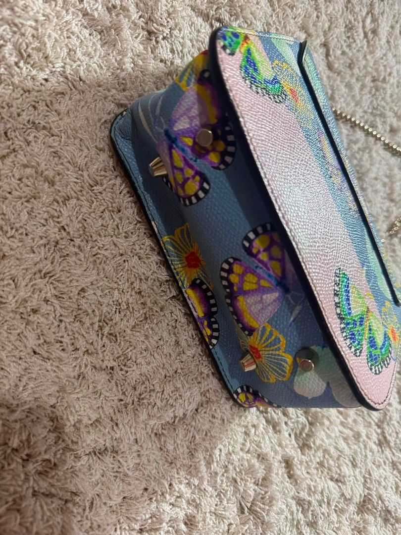 Furla Mini Butterfly Print Chain Bag (Category: Luxury Bags & Wallets) located in Manila. Submitted by shy177 (Listing ID 1461390544, Image 3). Description: - Cute Furla mini bag - Light blue and pink color palette - Features a charming butterfly and floral print - Elegant gold chain strap - Secure turn-lock closure - Ideal for evening events or adding a vibrant accent to any outfit - Compact and easy to carry.