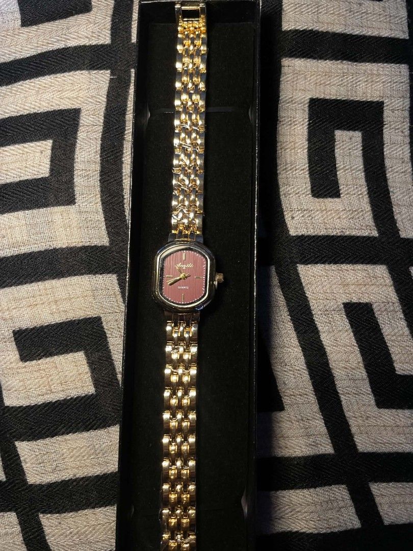 Gold Tone Quartz Watch with Pink Face (Category: Women's Watches) located in Impasugong. Submitted by gresha_closets (Listing ID 1461376238, Image 1). Description: - Elegant gold-tone watch - Pretty pink watch face - Square-ish case shape - Classic link style band - Accurate quartz movement - Includes original box - Versatile for everyday or special occasions.