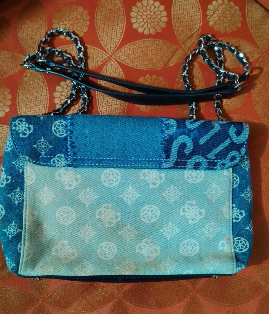 Guess Denim Patchwork Chain Shoulder Bag (Category: Shoulder Bags) located in Caloocan City. Submitted by tweetyferrer (Listing ID 1461352495, Image 2). Description: - Stylish Guess bag with unique denim patchwork design. - Features the iconic Guess logo printed all over. - Elegant silver chain strap accented with leather. - Interior pockets for convenient organization. - Versatile for everyday wear or evening outings..