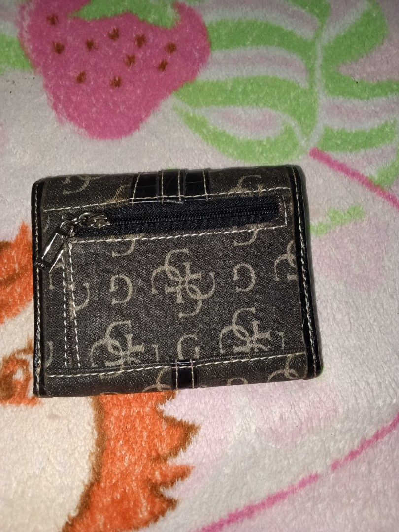 Guess Monogram Wallet with Ring Detail (Category: Wallets & Card holders) located in Manila. Submitted by aradoanita90032 (Listing ID 1461444830, Image 2). Description: - Authentic denim Guess wallet - Signature monogram pattern - Front flap closure with metal ring detail - Small zippered pocket on the back - Compact size, perfect for essentials - Shows some signs of wear, but fully functional.