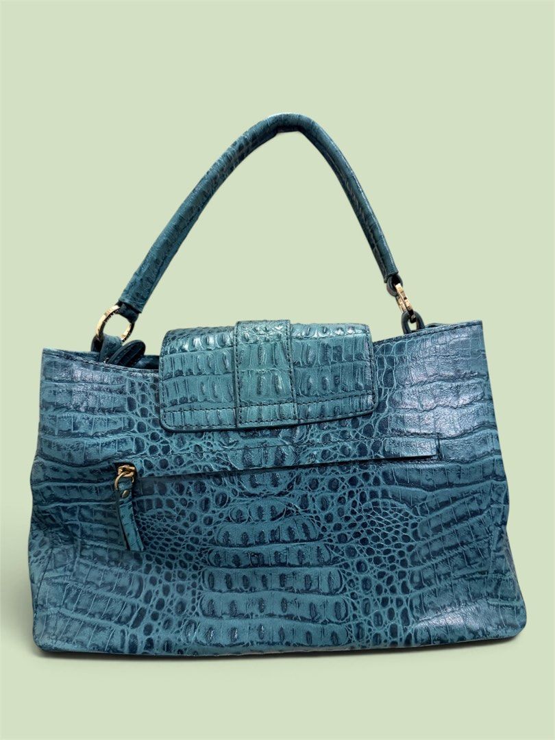 Guy Laroche Teal Crocodile Embossed Leather Handbag (Category: Luxury Bags & Wallets) located in Lapu Lapu. Submitted by warmwhale.be136e (Listing ID 1461486601, Image 2). Description: - Stylish teal handbag with a luxurious crocodile embossed finish. - Secure buckle closure on the front flap. - Comfortable top handle for easy carrying. - Detachable shoulder strap for versatile wear. - Convenient interior zippered pocket for essentials. - Elegant