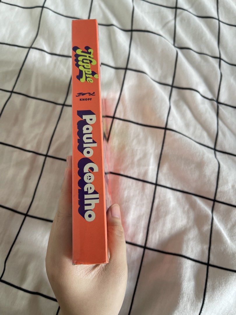 Hippie by Paulo Coelho Book (Category: Storybooks) located in Pasig City. Submitted by ceejay_29 (Listing ID 1461396247, Image 2). Description: - Paulo Coelho's 'Hippie' novel - Features an orange cover with groovy lettering - Spine clearly shows title and author - Pages are clean and well-maintained - Ideal for readers interested in self-discovery and travel.