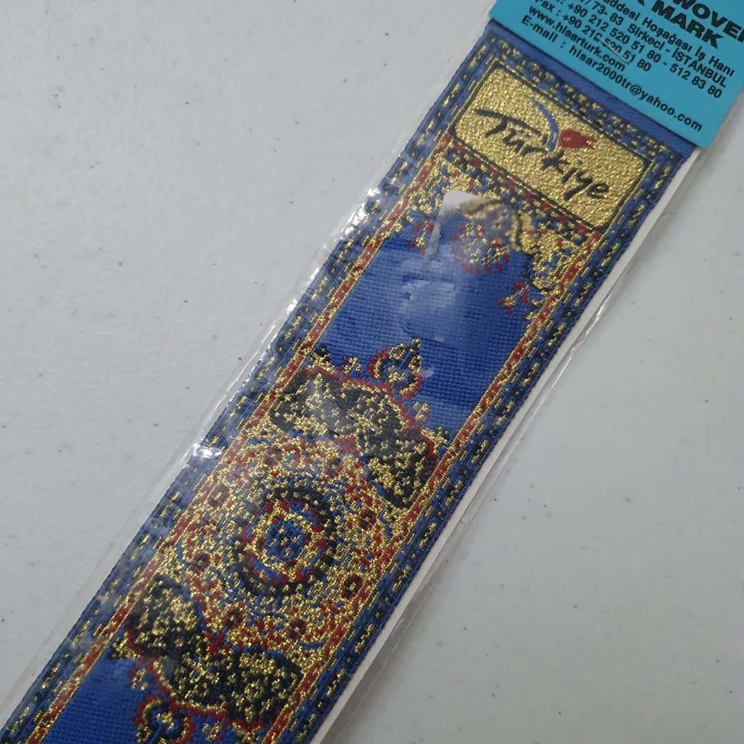 HISAR Turkish Woven Book Mark (Category: Stationery & School Supplies) located in Paranaque City. Submitted by cobien (Listing ID 1461538899, Image 2). Description: - Authentic HISAR Turkish woven bookmark - Beautiful blue and gold intricate pattern inspired by Turkish carpets - 'Türkiye' prominently displayed - Comes in original packaging - Ideal for book lovers or as a souvenir.
