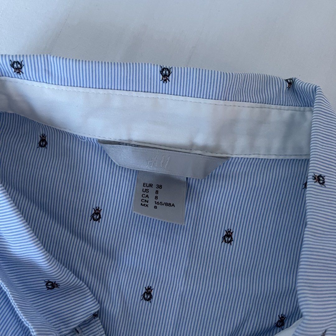 H&M Blue Striped Shirt with Bug Print (Category: Shirts) located in Muntinlupa City. Submitted by sza1123 (Listing ID 1461414413, Image 2). Description: - Light blue H&M button-up shirt - Subtle black bug pinstripe pattern - Long sleeves with button cuffs - Single chest pocket - Perfect for casual wear or layering.