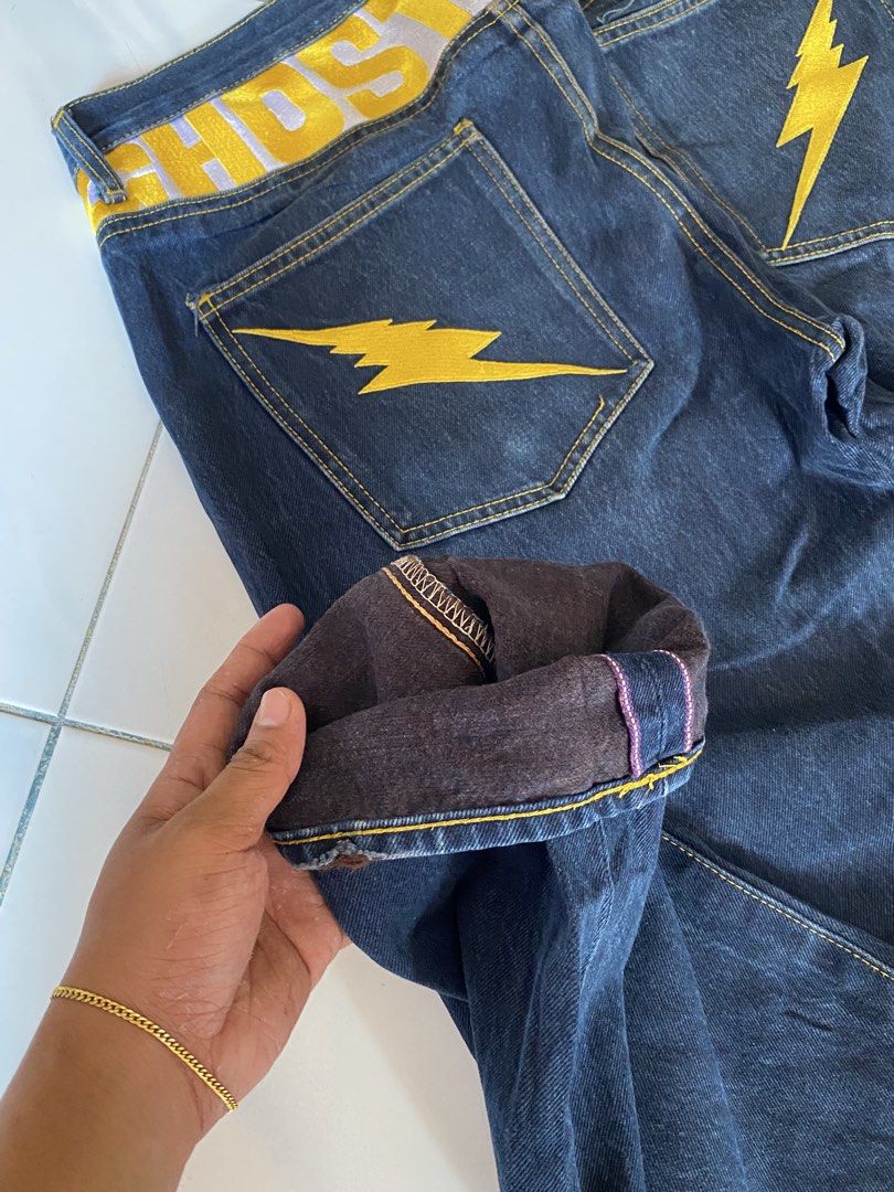 HOSTED Jeans with Yellow Lightning Bolt Pockets (Category: Jeans) located in Borongan. Submitted by cybutdiff (Listing ID 1461422655, Image 3). Description: - Dark wash denim jeans - Yellow lightning bolt embroidery on back pockets - Bold yellow 'HOSTED' print on waistband - Button fly closure - Noticeable fabric fading - Perfect statement piece for a bold look.