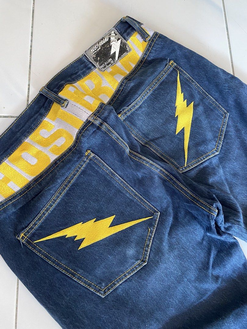 HOSTED Jeans with Yellow Lightning Bolt Pockets (Category: Jeans) located in Borongan. Submitted by cybutdiff (Listing ID 1461422655, Image 2). Description: - Dark wash denim jeans - Yellow lightning bolt embroidery on back pockets - Bold yellow 'HOSTED' print on waistband - Button fly closure - Noticeable fabric fading - Perfect statement piece for a bold look.