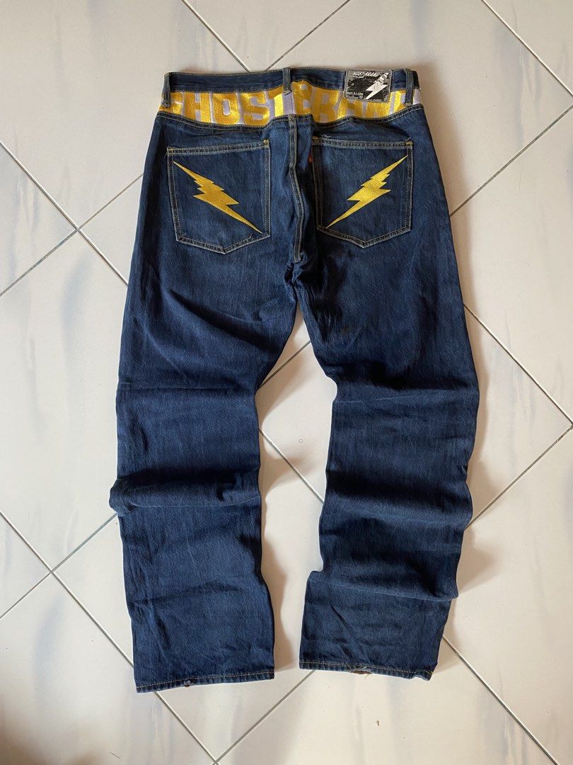 HOSTED Jeans with Yellow Lightning Bolt Pockets (Category: Jeans) located in Borongan. Submitted by cybutdiff (Listing ID 1461422655, Image 1). Description: - Dark wash denim jeans - Yellow lightning bolt embroidery on back pockets - Bold yellow 'HOSTED' print on waistband - Button fly closure - Noticeable fabric fading - Perfect statement piece for a bold look.