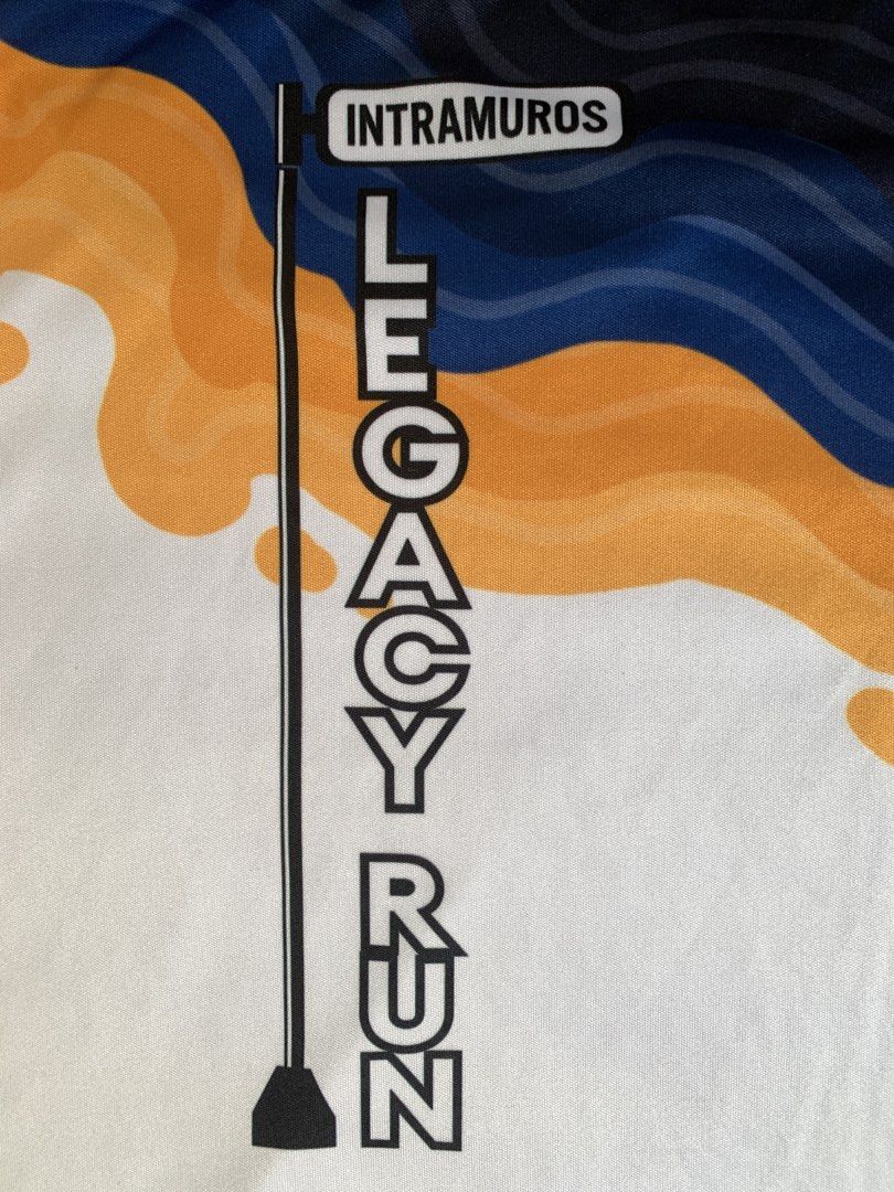 Intramuros Legacy Run T-shirt (Category: Activewear) located in Taguig. Submitted by ahnjr (Listing ID 1461452308, Image 2). Description: - Unique white t-shirt with a cool graphic design. - Features a vertical street sign: 'Intramuros' and 'Legacy Run'. - Abstract shapes in orange, blue, and black add a modern touch. - Comfortable fabric for everyday wear. - Ideal for runners or those who appreciate distinctive designs..