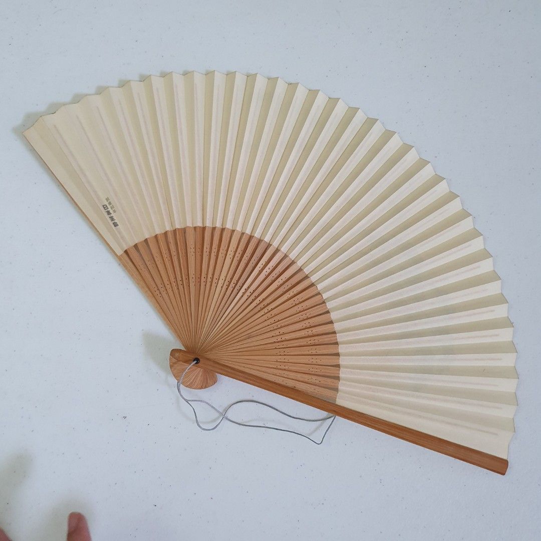 Japanese Style Folding Fan with Bamboo Handle (Category: Fans) located in Paranaque City. Submitted by cobien (Listing ID 1461481389, Image 2). Description: - Classic folding fan with a natural bamboo handle. - Features a delicate green bamboo leaf design on a cream-colored paper. - Compact folding design for easy storage and portability. - Includes a convenient string loop for hanging. - Ideal for staying cool on hot days or as a charming decora