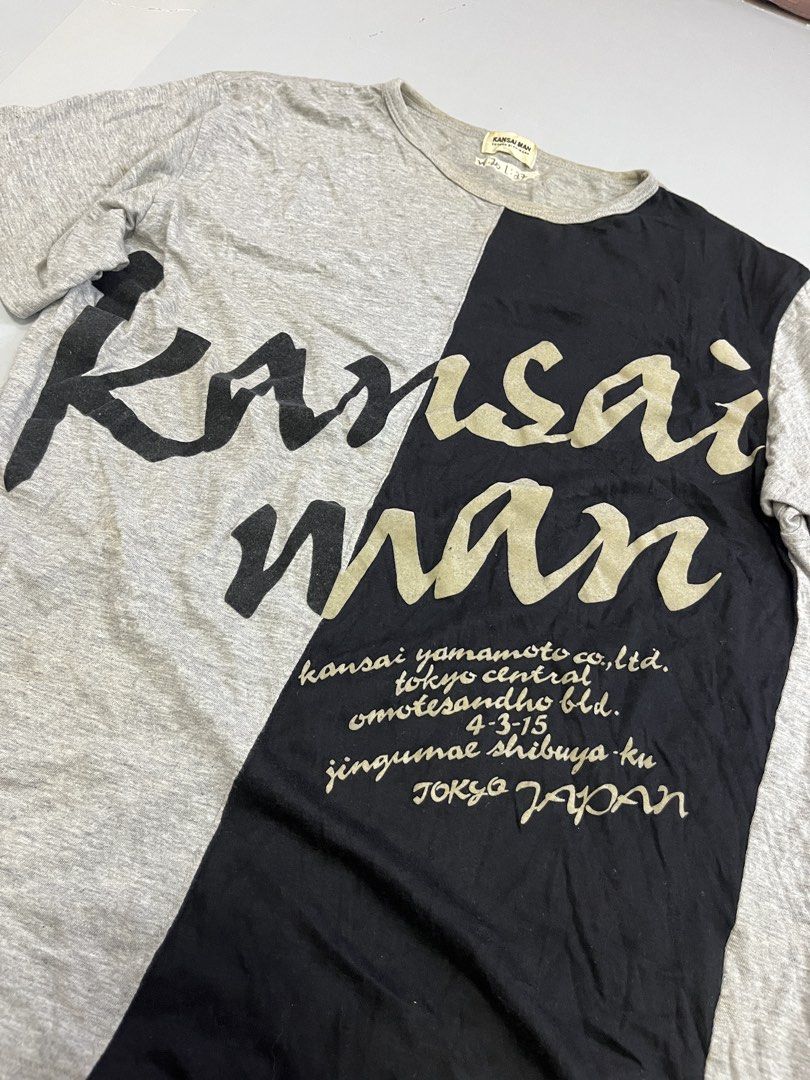 Kansai Man Yamamoto T-shirt Grey Black Split Design (Category: Tshirts & Polo Shirts ) located in Mabalacat. Submitted by aas_thriftfings (Listing ID 1461516613, Image 2). Description: - Authentic Kansai Man t-shirt - Striking grey and black split design - Bold 'Kansai Man' graphic - Features brand's Tokyo address detail - Comfortable cotton blend fabric - Size L (check measurements for best fit) - Ideal statement piece for streetwear enthusiasts