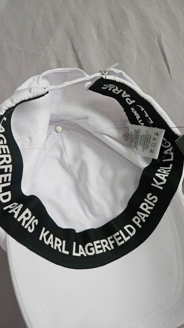Karl Lagerfeld White Cap with Charms (Category: Hats & Beanies) located in Rizal. Submitted by vanbdc24 (Listing ID 1461379525, Image 2). Description: - bought $120 authentic Karl Lagerfeld cap - Features unique charms: sunglasses, guitar, tie - Adjustable strap for a perfect fit - Interior black band with Karl Lagerfeld branding - Adds a stylish flair to any outfit.