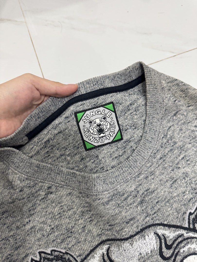 Kenzo Paris Tiger Logo Grey Sweatshirt (Category: Coats, Jackets and Outerwear) located in Manila. Submitted by yelutot (Listing ID 1461545756, Image 3). Description: - Grey Kenzo sweatshirt - Features iconic tiger logo - 'KENZO PARIS' text below graphic - Long sleeves - Crew neck - Ideal for comfortable and stylish casual wear.
