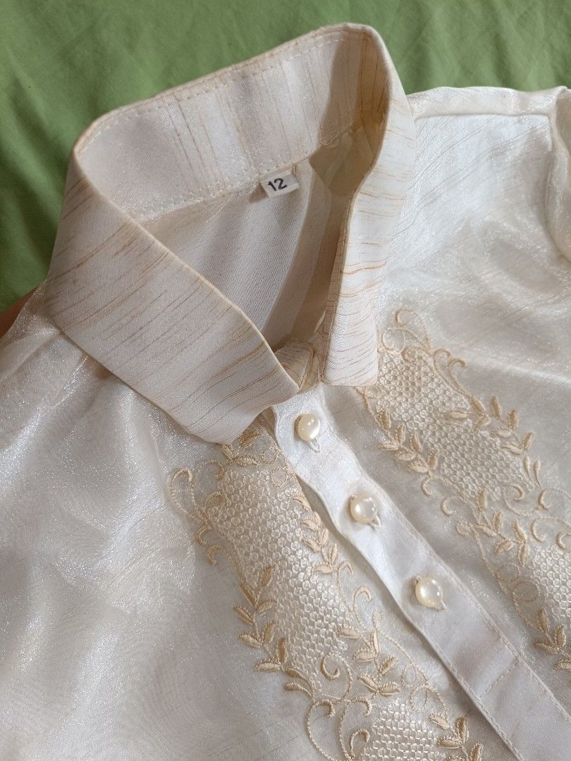 Kids Barong Tagalog - Size 12 (Category: Formal Shirts) located in Manila. Submitted by mecaart (Listing ID 1461409760, Image 3). Description: - Cream-colored Barong Tagalog shirt for boys - Size 12 - Pina Jusi - Intricate embroidery on the front - Long sleeves with button cuffs - Ideal for formal events and celebrations RFS: once lang nagamit during BUWAN NG WIKA celebration in school. Natambak lang. Maganda in person, makapal.