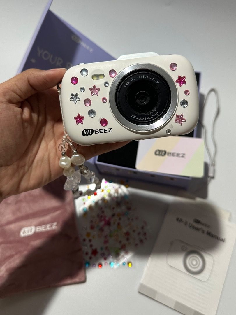 Kit Beez KF-3 Digital Camera with Accessories (Category: Cameras) located in Calamba. Submitted by daisy214 (Listing ID 1461540509, Image 2). Description: - Cute white Kit Beez KF-3 digital camera - Comes with a cute beaded strap - Includes stickers for decoration - User manual included - Comes with a pink pouch - Everything is in the original box - Great for kids or anyone who loves a fun, retro camera.