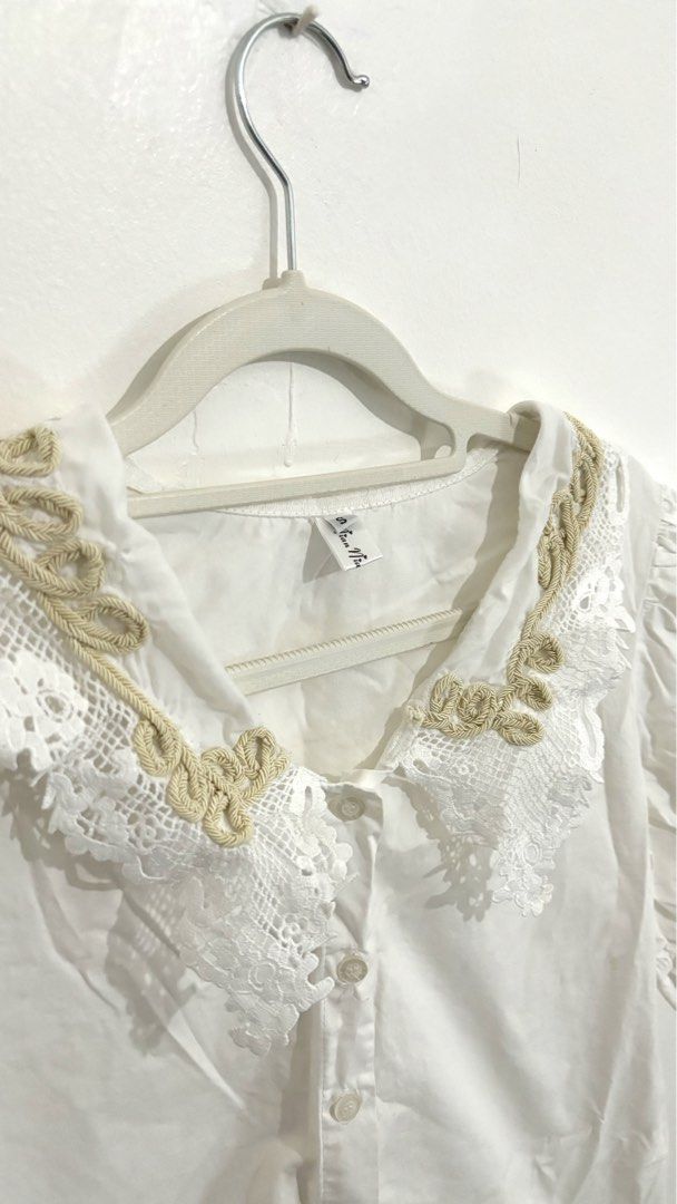 Lace-Collar Puff-Sleeve Button-Down Blouse (Category: Blouses) located in Caloocan City. Submitted by buymethisandthat (Listing ID 1461402161, Image 2). Description: ✨ Lace-Collar Puff-Sleeve Button-Down Blouse - ₱99 📌 CONDITION • Condition: 7.5/10 • Flaws: Faint yellowish stains/discoloration on lower front bodice and hem area 📏 SIZE • Tag Size: No size tag • Recommended: Fits Small to Medium .