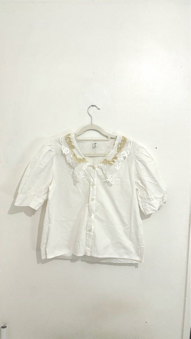 Lace-Collar Puff-Sleeve Button-Down Blouse (Category: Blouses) located in Caloocan City. Submitted by buymethisandthat (Listing ID 1461402161, Image 1). Description: ✨ Lace-Collar Puff-Sleeve Button-Down Blouse - ₱99 📌 CONDITION • Condition: 7.5/10 • Flaws: Faint yellowish stains/discoloration on lower front bodice and hem area 📏 SIZE • Tag Size: No size tag • Recommended: Fits Small to Medium .