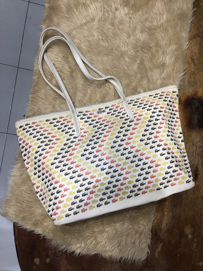 LACOSTE PVC Tote Bag (Category: Tote Bags) located in Quezon City. Submitted by bettymeir07 (Listing ID 1461545453, Image 1). Description: White Lacoste PVC tote bag with an all-over multicolored crocodile logo pattern and dual shoulder straps. -Has issues with straps design, broken zipper, spilled ink inside the bag -Well used condition -PRICE NEGOTIABLE MOP: GOTYME or GCASH.