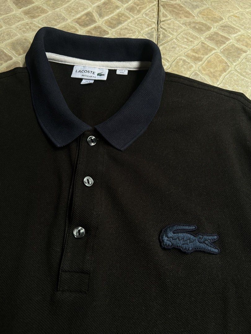Lacoste Regular Fit Polo Shirt Black (Category: Tshirts & Polo Shirts ) located in Pasay City. Submitted by deguzmanjay (Listing ID 1461517246, Image 2). Description: - Classic black Lacoste polo shirt - Regular fit - Iconic crocodile logo on chest - Contrasting navy collar and sleeve cuffs - Button-up neckline - Made in Peru - Ideal for casual or smart-casual outfits.