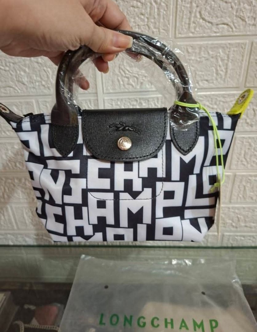 Le Pliage Cuir XS Top Handle Bag (Category: Cross-body Bags) located in Manila. Submitted by katkween23 (Listing ID 1461446478, Image 3). Description: - Super cute Longchamp bag - All-over logo print in black and white - Features top handles - Detachable shoulder strap included - Comes with original tag and dust bag - Small size, ideal for essentials - Versatile for everyday use or nights out.