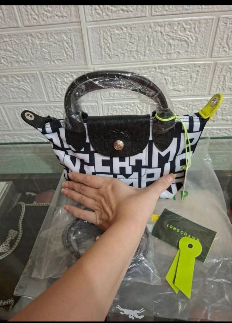 Le Pliage Cuir XS Top Handle Bag (Category: Cross-body Bags) located in Manila. Submitted by katkween23 (Listing ID 1461446478, Image 2). Description: - Super cute Longchamp bag - All-over logo print in black and white - Features top handles - Detachable shoulder strap included - Comes with original tag and dust bag - Small size, ideal for essentials - Versatile for everyday use or nights out.