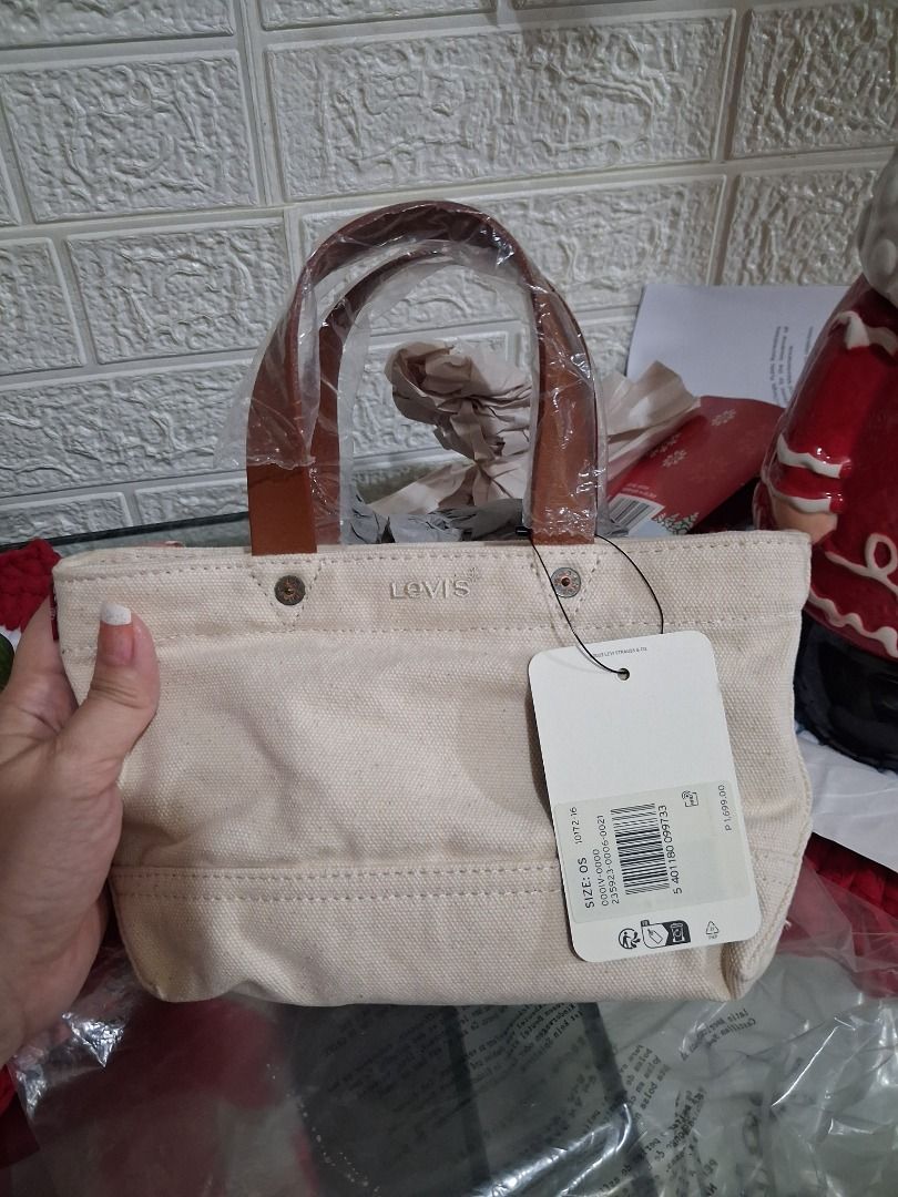 Levi's Heritage Micro Tote Bag - White Canvas (Category: Tote Bags) located in Manila. Submitted by katkween23 (Listing ID 1461448163, Image 1). Description: White canvas tote bag from Levi's. Has brown faux leather handles. Perfect size for essentials. Comes with original tags and receipt. Bought recently. Selling because it's an impulse buy..