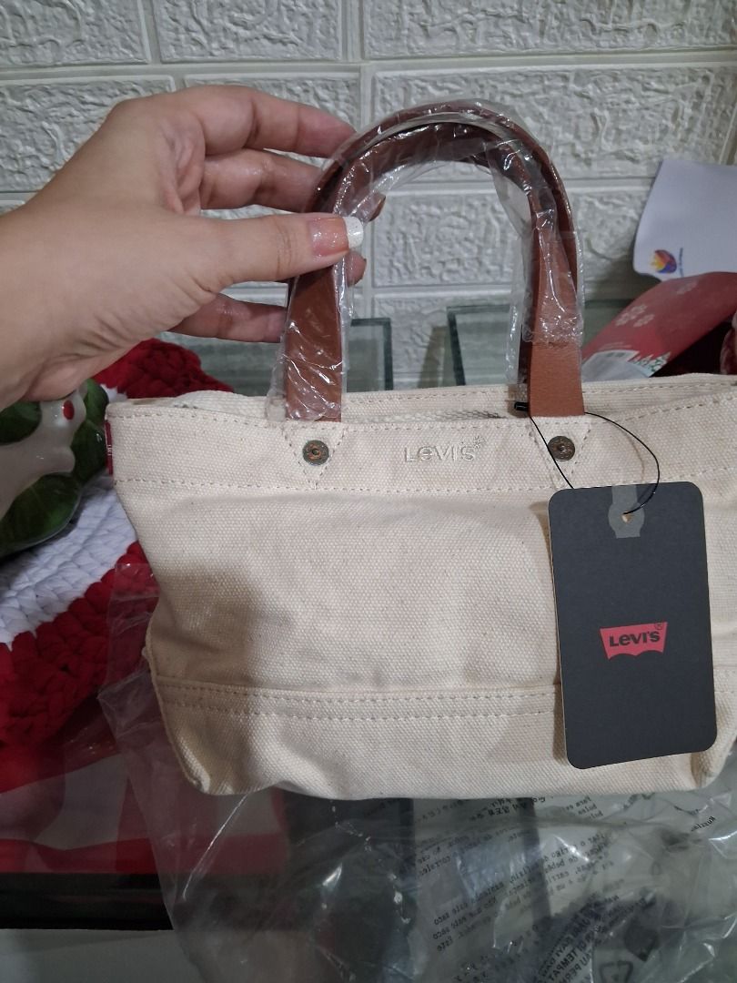 Levi's Heritage Micro Tote Bag - White Canvas (Category: Tote Bags) located in Manila. Submitted by katkween23 (Listing ID 1461448163, Image 3). Description: White canvas tote bag from Levi's. Has brown faux leather handles. Perfect size for essentials. Comes with original tags and receipt. Bought recently. Selling because it's an impulse buy..