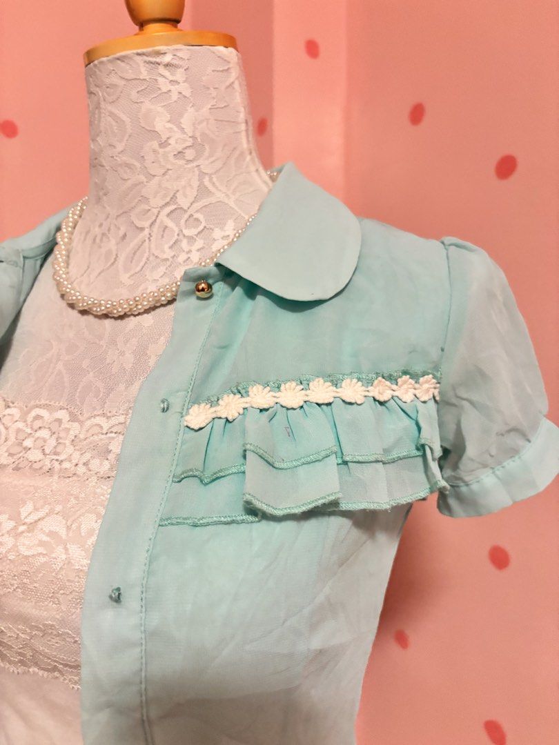 Light Blue Short Sleeve Button Up Blouse with Ruffles (Category: Blouses) located in Pagadian. Submitted by purewonderofsparkles (Listing ID 1461333437, Image 2). Description: - Cute light blue short sleeve blouse - Features a classic Peter Pan collar - Button-up front for easy wear - Adorable ruffled details with white lace trim on chest and sleeves - Made from lightweight material - Perfect for both casual outings and dressier events BLOUSE ONL
