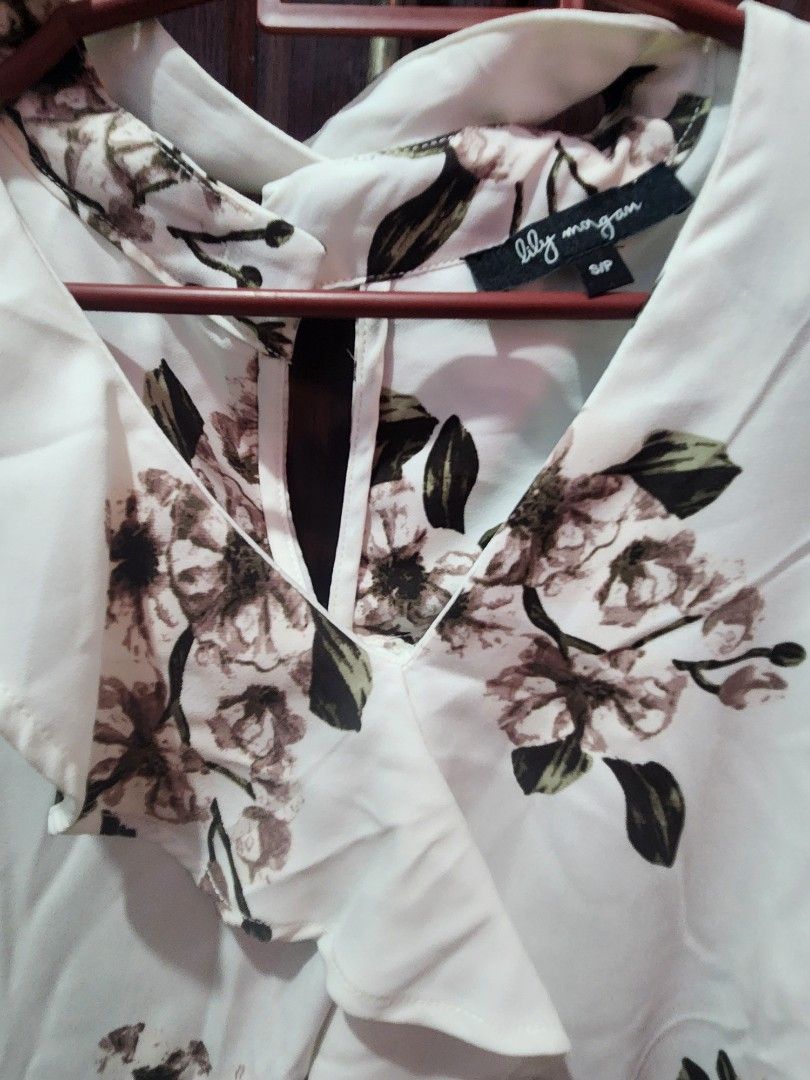 Lily Morgan White Floral Blouse (Category: Blouses) located in Muntinlupa City. Submitted by yanyan1888 (Listing ID 1461370282, Image 2). Description: - Pretty white blouse with a floral print - Light and flowy fabric - Collared neckline - Button-up front - Versatile: dress up or down - Easy to style with jeans or skirts.
