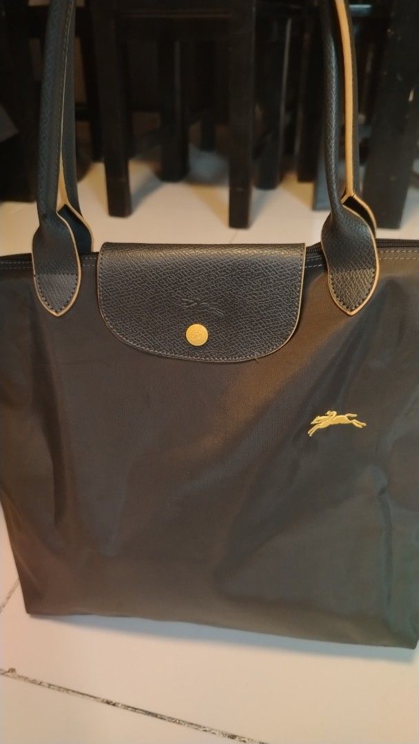 Longchamp Le Pliage Shopping Tote Bag (Category: Luxury Bags & Wallets) located in Manila. Submitted by wildwind_73f77a (Listing ID 1461483222, Image 1). Description: - Classic Longchamp tote bag - Color: Dark Grey - Material: Leather trim and handles - Closure: Zipper with snap button flap - Features: Spacious interior - Ideal for: Everyday use or travel.