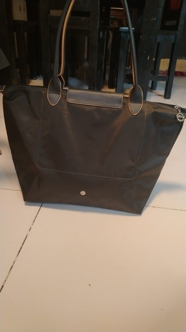 Longchamp Le Pliage Shopping Tote Bag (Category: Luxury Bags & Wallets) located in Manila. Submitted by wildwind_73f77a (Listing ID 1461483222, Image 2). Description: - Classic Longchamp tote bag - Color: Dark Grey - Material: Leather trim and handles - Closure: Zipper with snap button flap - Features: Spacious interior - Ideal for: Everyday use or travel.