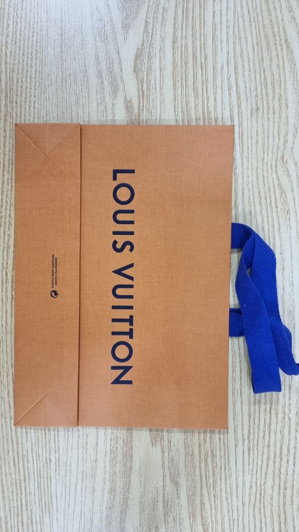 Louis Vuitton Shopping Bag (Category: Luxury Bags & Wallets) located in Paranaque City. Submitted by olxph_668280920 (Listing ID 1461474536, Image 2). Description: - Authentic Louis Vuitton shopping bag - Color: Brown paper with blue handles - Dimensions: 11 x 8 x 3.5 inches - Features: "Maison fondée en 1854 Paris" - Ideal for: Storing small items or as a gift bag.