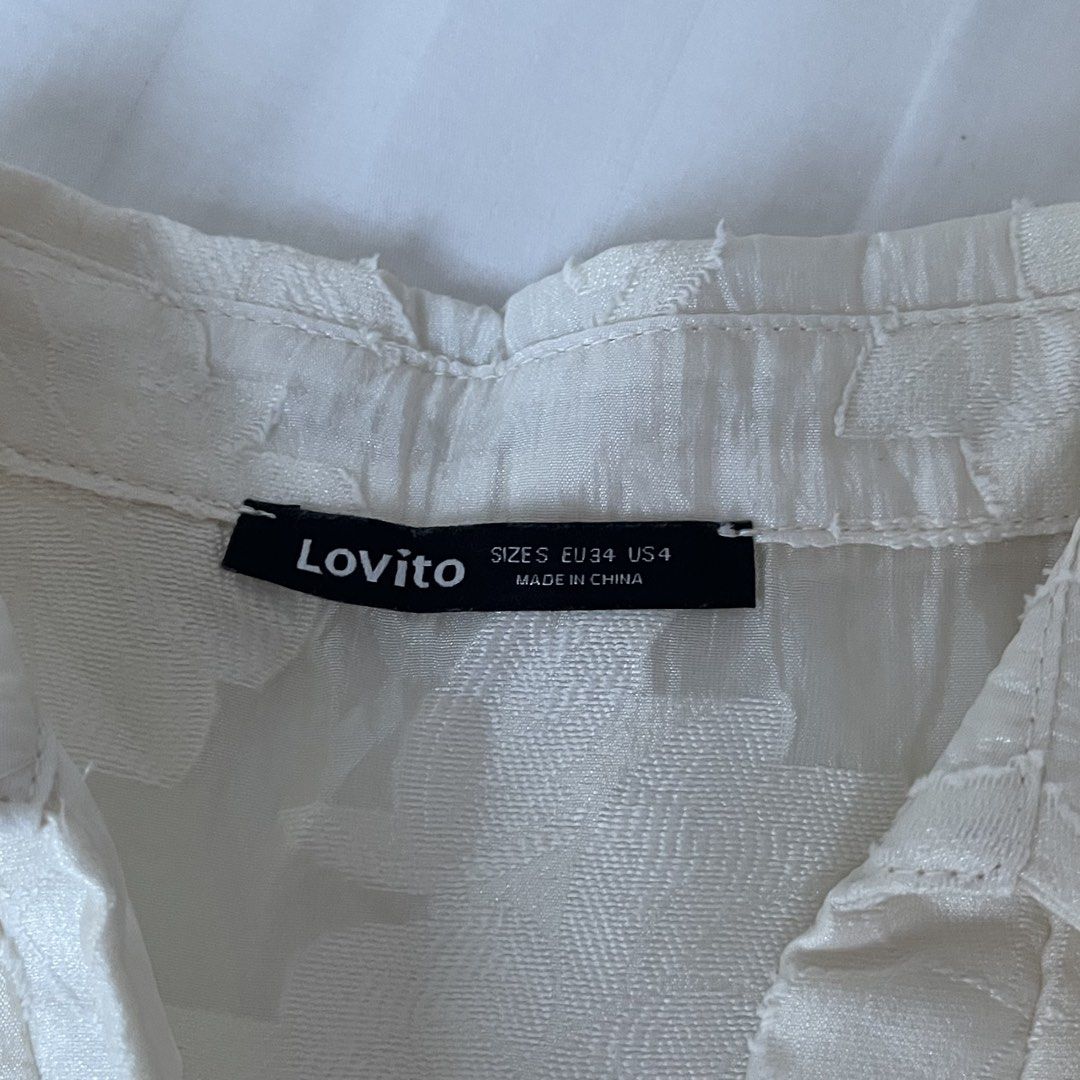 Lovito White Textured Puff Sleeve Cropped Blouse (Category: Blouses) located in Muntinlupa City. Submitted by sza1123 (Listing ID 1461415779, Image 2). Description: - White cropped blouse from Lovito - Textured fabric with a subtle floral-like pattern - Stylish puff sleeves - Elegant pearl-like buttons down the front - Classic collar neckline - Versatile for pairing with high-waisted bottoms - Effortlessly chic and easy to style.