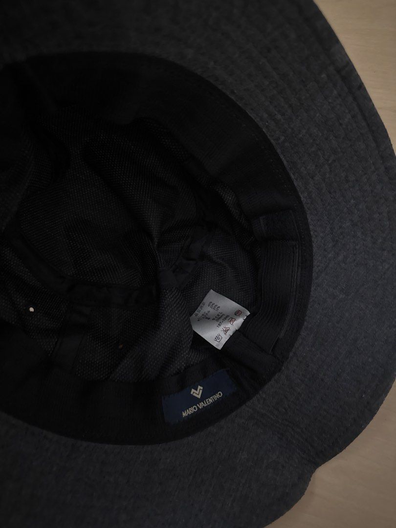 Mario Valentino Bucket Hat 🇯🇵 (Category: Hats & Beanies) located in Manila. Submitted by juhjuh (Listing ID 1461380170, Image 2). Description: - Mario Valentino dark grey bucket hat - Small - Made from a textured fabric - Simple, versatile design perfect for everyday wear - Features a small brand name tag - Please check photos for detailed condition.