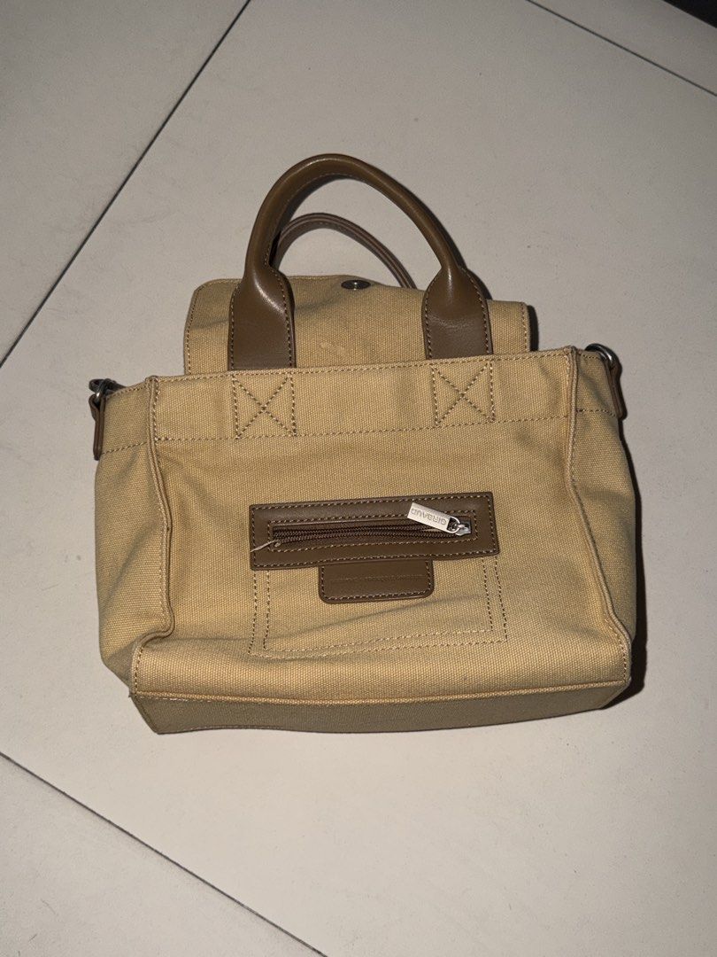 Marithe Girbaud Canvas Handbag (Category: Luxury Bags & Wallets) located in Manila. Submitted by hatdognablue (Listing ID 1461360888, Image 1). Description: - Marithe Girbaud canvas handbag - Tan color with brown leather accents - Top handles and adjustable crossbody strap - Front zip pocket for quick access - Spacious main compartment - Interior zip pocket for essentials - Ideal for everyday use.
