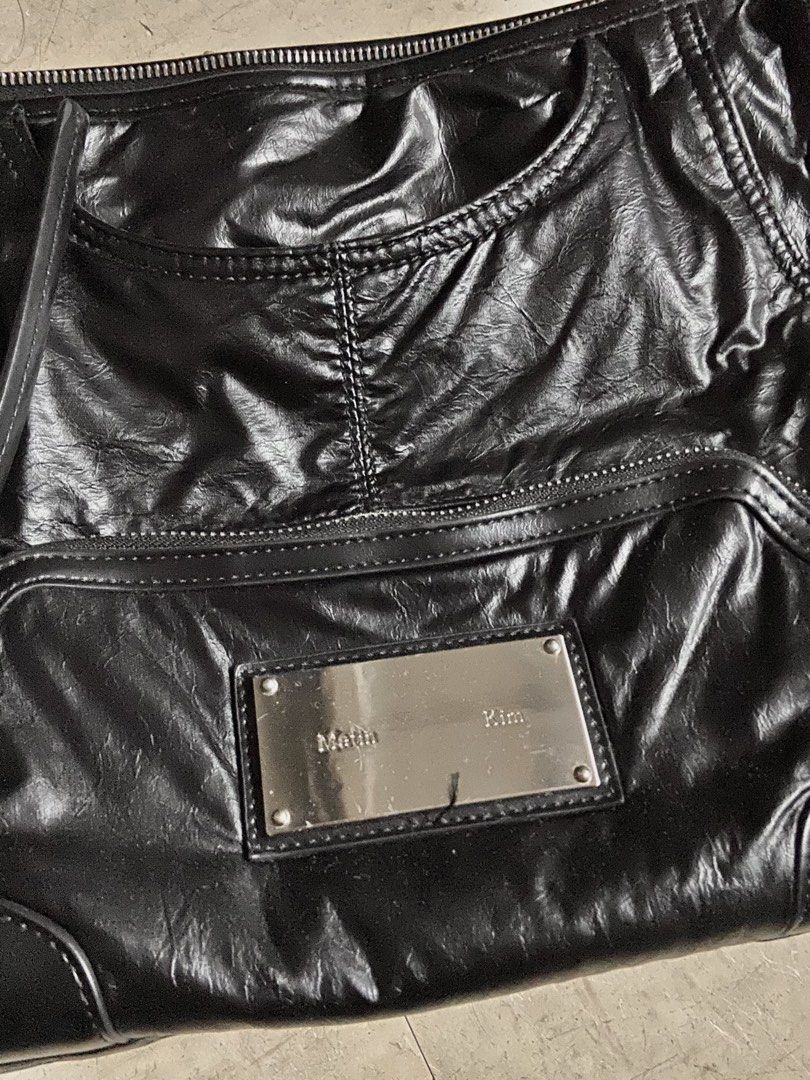 Matin Kim Black Leather Shoulder Bag (Category: Shoulder Bags) located in Manila. Submitted by reirapture (Listing ID 1461442582, Image 2). Description: - Brand: Matin Kim - Material: Black Leather - Finish: Shiny, slightly crinkled - Features: Multiple zippered pockets, front pouch - Straps: Adjustable with buckle details - Hardware: Silver-tone logo plate - Interior: Spacious, ideal for everyday use NEGOTIABLE PA!!!.