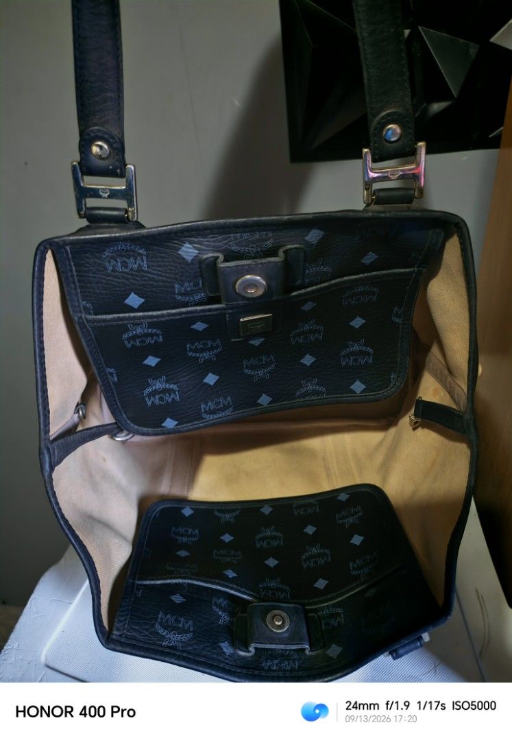 MCM Tote Bag Black Monogram (Category: Luxury Bags & Wallets) located in Manila. Submitted by cleverwhale_45b7bc (Listing ID 1461432317, Image 3). Description: - Classic MCM tote bag - Black with signature monogram pattern - Leather handles and trim - Interior: zippered pocket and open compartments - Note: Some stains inside the main compartment - Metal logo plate on the front -turnable screw.