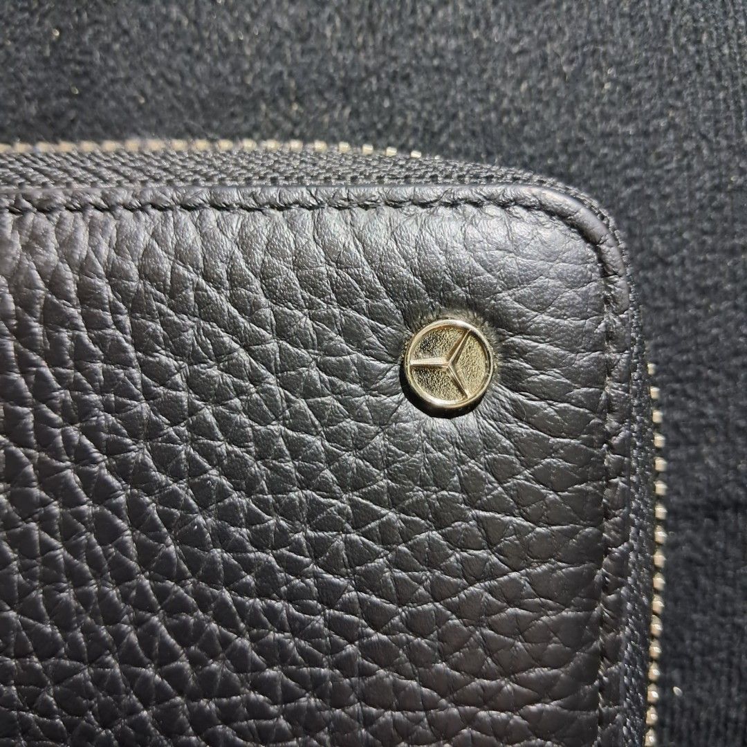 Mercedes-Benz Zip-Around Long Wallet (Category: Luxury Bags & Wallets) located in Butuan. Submitted by fabchichub (Listing ID 1461460577, Image 2). Description: This Mercedes-Benz zip-around long wallet is crafted from textured black pebbled leather, combining a minimalist design with sleek business functionality. It features a secure full-zip closure and is accented by a subtle, polished Mercedes-Benz star emblem on the upper right corner..