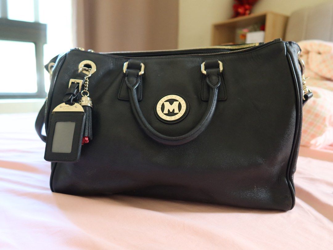 METROCITY Black Leather Satchel Handbag (Category: Shoulder Bags) located in Pasig City. Submitted by simplylizzy (Listing ID 1461336483, Image 1). Description: - METROCITY black leather satchel bag - Secure top zip closure - Multiple interior compartments for organization - Detachable ID holder and tassel charm included - Stylish gold hardware details - Spacious design for daily essentials.