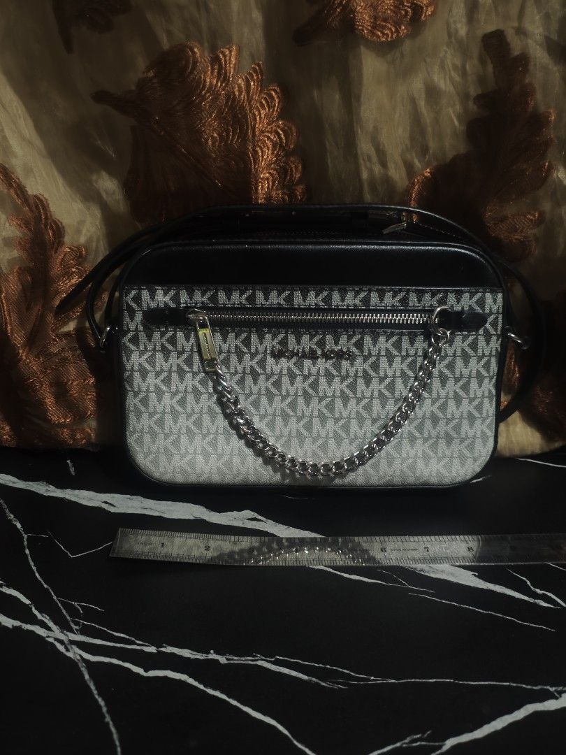 Michael Kors MK Signature Monogram Camera Bag (Category: Luxury Bags & Wallets) located in San Fernando. Submitted by brandeddeclutter. (Listing ID 1461439222, Image 1). Description: - Authentic Michael Kors camera bag - Signature black and white MK print - Stylish silver chain detail - Adjustable leather strap for comfort - Secure zipper closure - Interior tag with model/serial number - Ideal for everyday use.