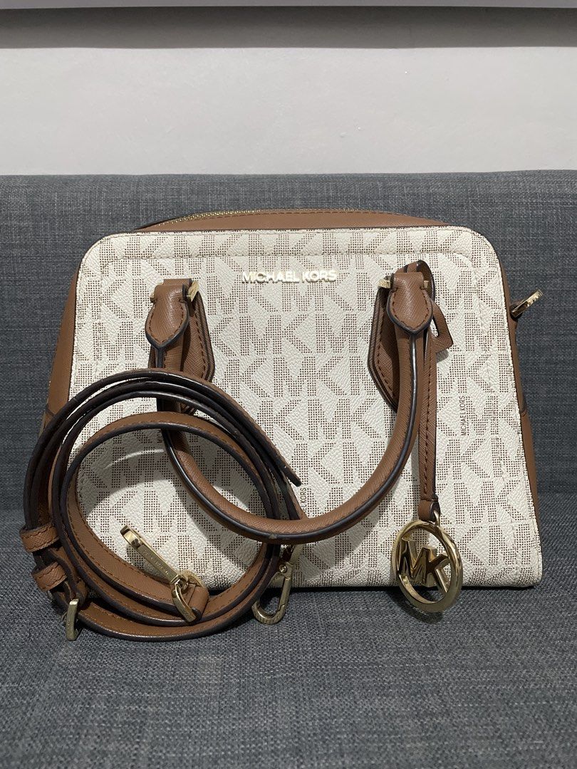 Michael Kors Monogram Satchel Bag with Strap (Category: Luxury Bags & Wallets) located in Pasig City. Submitted by roseyyylife (Listing ID 1461454246, Image 1). Description: - Authentic Michael Kors monogram satchel - Signature MK print in vanilla and brown - Elegant gold hardware details - Features a secure top zip closure - Comes with a detachable shoulder strap for versatile carrying - Note: Small pink mark visible on the underside - Ideal for