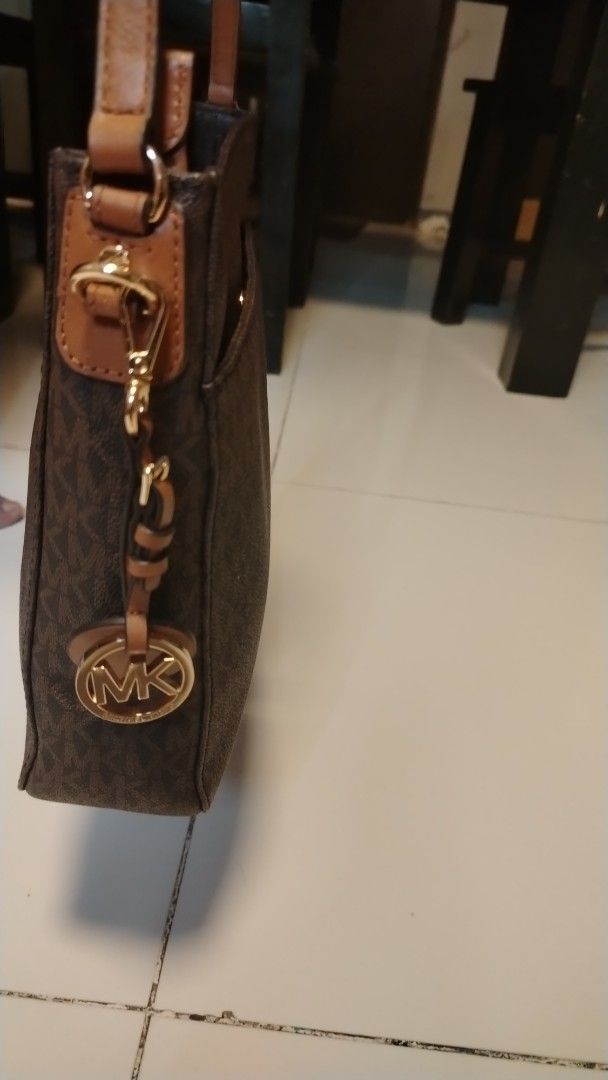 Michael Kors Monogram Shoulder Bag (Category: Luxury Bags & Wallets) located in Manila. Submitted by wildwind_73f77a (Listing ID 1461486040, Image 3). Description: - Authentic Michael Kors shoulder bag in classic brown. - Features the iconic all-over MK monogram pattern. - Accented with stylish tan leather strap and details. - Elegant gold-tone hardware throughout. - Includes the signature MK charm for an extra touch of luxury. - A versatile and 