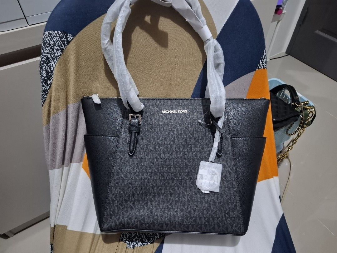 Michael Kors Tote Bag (Category: Luxury Bags & Wallets) located in Manila. Submitted by liveeagle-c6d8 (Listing ID 1461489013, Image 1). Description: - Authentic Michael Kors tote bag - Classic black and grey signature MK pattern - Convenient side pockets - Secure zip top closure - Handles still protected with original plastic wrap - 100% legit original from USA. - Ideal for everyday use and errands.