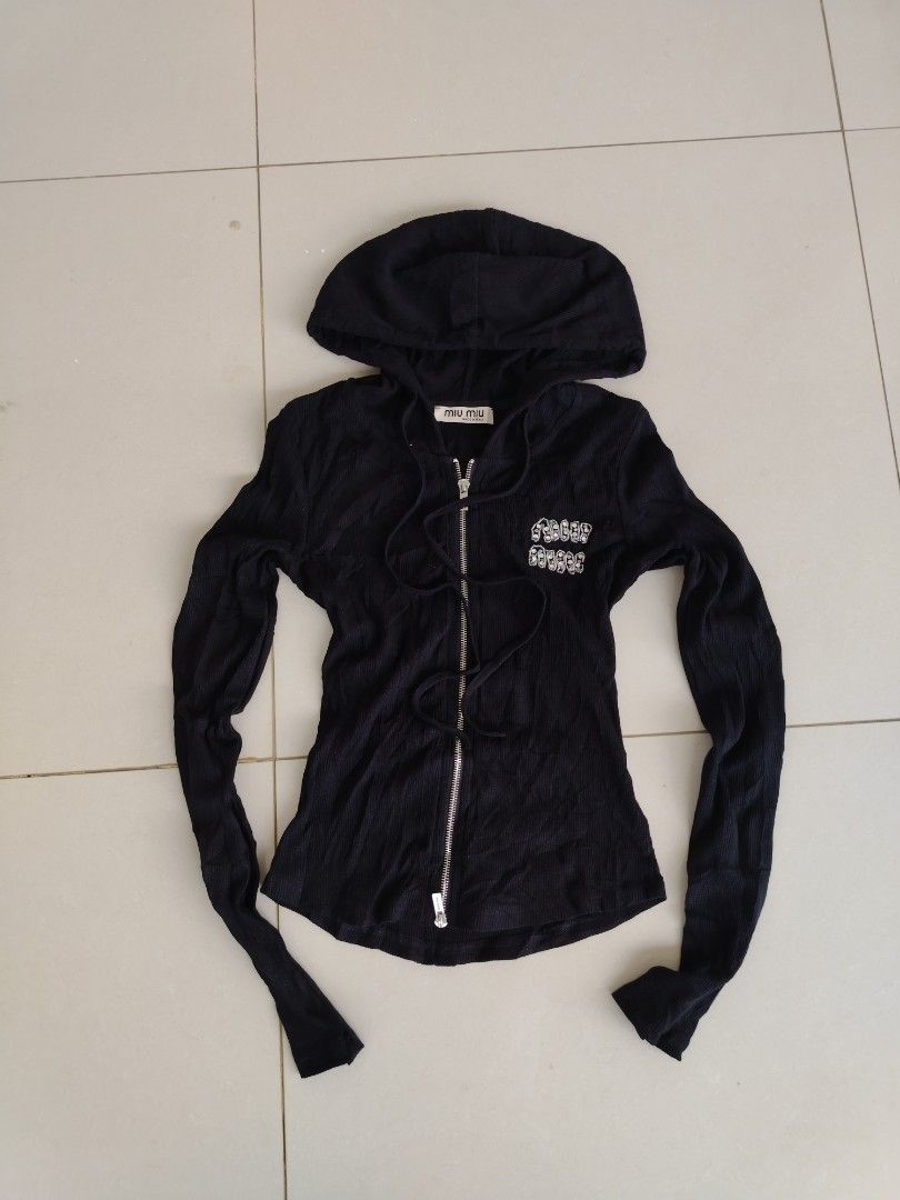 Miu miu (Category: Coats, Jackets and Outerwear) located in Don Carlos. Submitted by thriftnidodong_23 (Listing ID 1461386619, Image 1). Description: This is a black ribbed Miu Miu zip-up hoodie featuring a sparkly rhinestone logo detail on the chest.