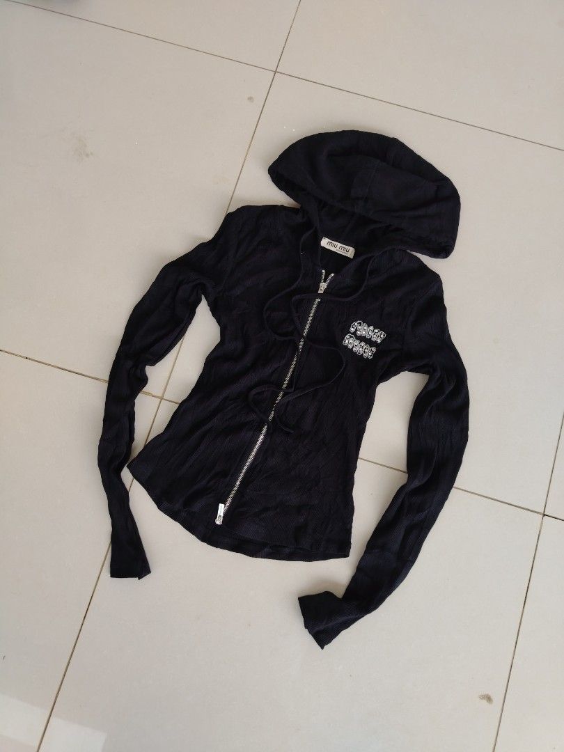 Miu miu (Category: Coats, Jackets and Outerwear) located in Don Carlos. Submitted by thriftnidodong_23 (Listing ID 1461386619, Image 2). Description: This is a black ribbed Miu Miu zip-up hoodie featuring a sparkly rhinestone logo detail on the chest.