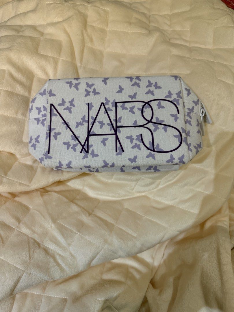 NARS Butterfly Print Cosmetic Bag (Category: Purses & Pouches) located in Muntinlupa City. Submitted by everythingmustgo_8475da (Listing ID 1461486590, Image 1). Description: - Cute NARS makeup bag - White base with all-over purple butterfly print - Zipper closure with NARS branded pulls - Small silica gel packet still inside - Ideal for organizing makeup or toiletries.