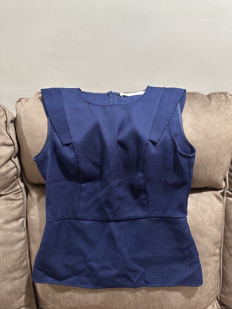 Navy Blue Sleeveless Peplum Top (Category: Sleeveless) located in Manila. Submitted by nasalgahan76152 (Listing ID 1461467677, Image 1). Description: - Sleeveless navy blue peplum top - Textured fabric for a unique feel - Convenient back zipper closure - Flattering fitted waist with a flared hem - Perfect for dressing up or down.