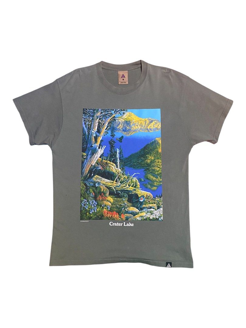 Nike ACG Oregon Lake (Category: Tshirts & Polo Shirts ) located in Manila. Submitted by bapekiddos (Listing ID 1461494101, Image 1). Description: - Grey t-shirt with a vibrant, detailed graphic print of Crater Lake, Oregon. - Front design: 'Crater Lake' - Back design: 'Oregon' - Brand: All Conditions Gear 2021 - Estimated Size: Medium (based on tag) - Ideal for nature enthusiasts and fans of Oregon. - High-quality, colorful print. -21x28 -verygoo