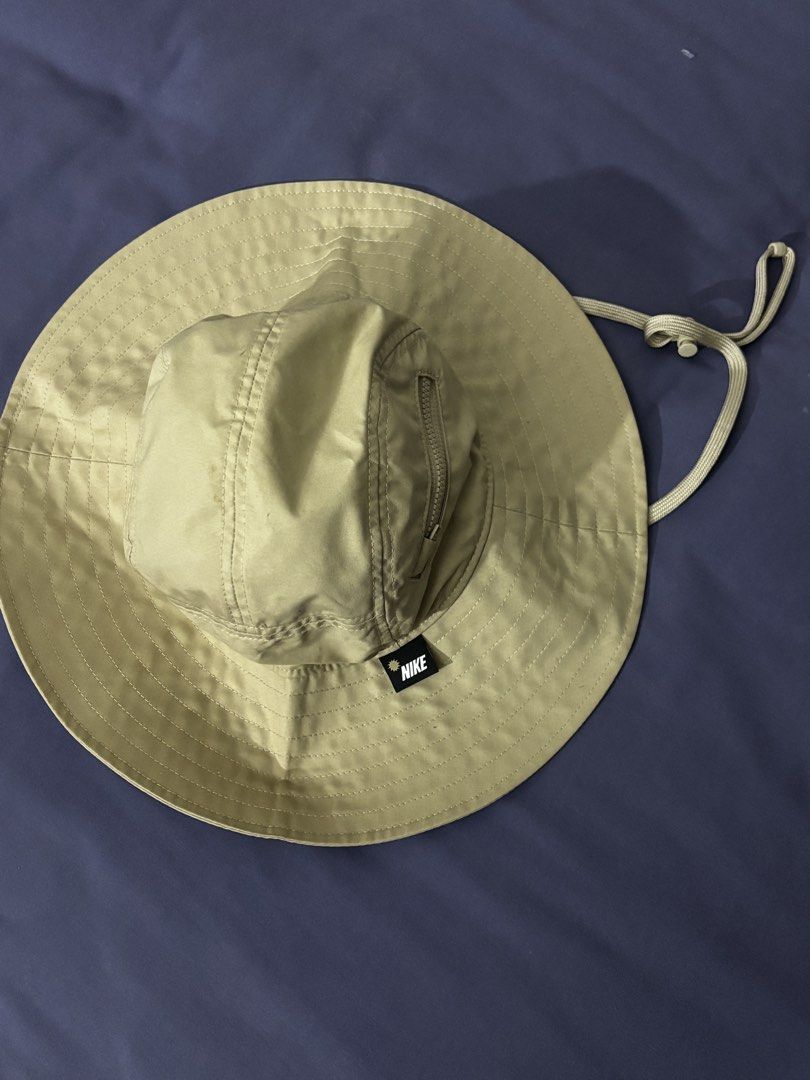 Nike Bucket Hat Khaki Size M (Category: Caps & Hats) located in Olongapo. Submitted by lovejeansph (Listing ID 1461362907, Image 1). Description: - Khaki Nike bucket hat - Size: Medium (M) - Convenient zip pocket on the crown - Adjustable chin strap with toggle for a secure fit - Ideal for outdoor adventures and casual wear.