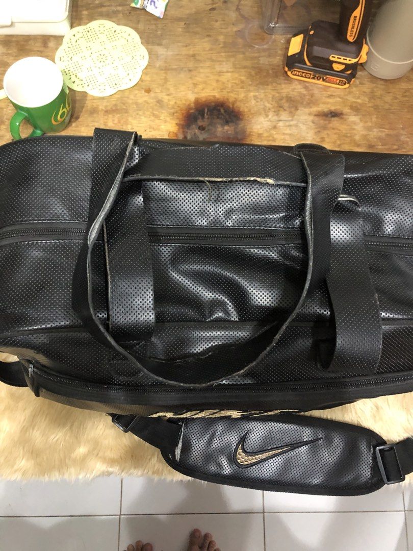 NIKE Duffel Bag (Category: Other Sports Equipment and Supplies) located in Quezon City. Submitted by bettymeir07 (Listing ID 1461544923, Image 2). Description: Black perforated Nike duffel bag featuring metallic gold snakeskin-textured branding. -Issues with the strap design -Well used condition -PRICE NEGOTIABLE MOP: GOTYME or GCASH.